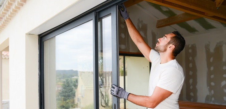 Handsome,young,man,installing,bay,window,in,a,new,house